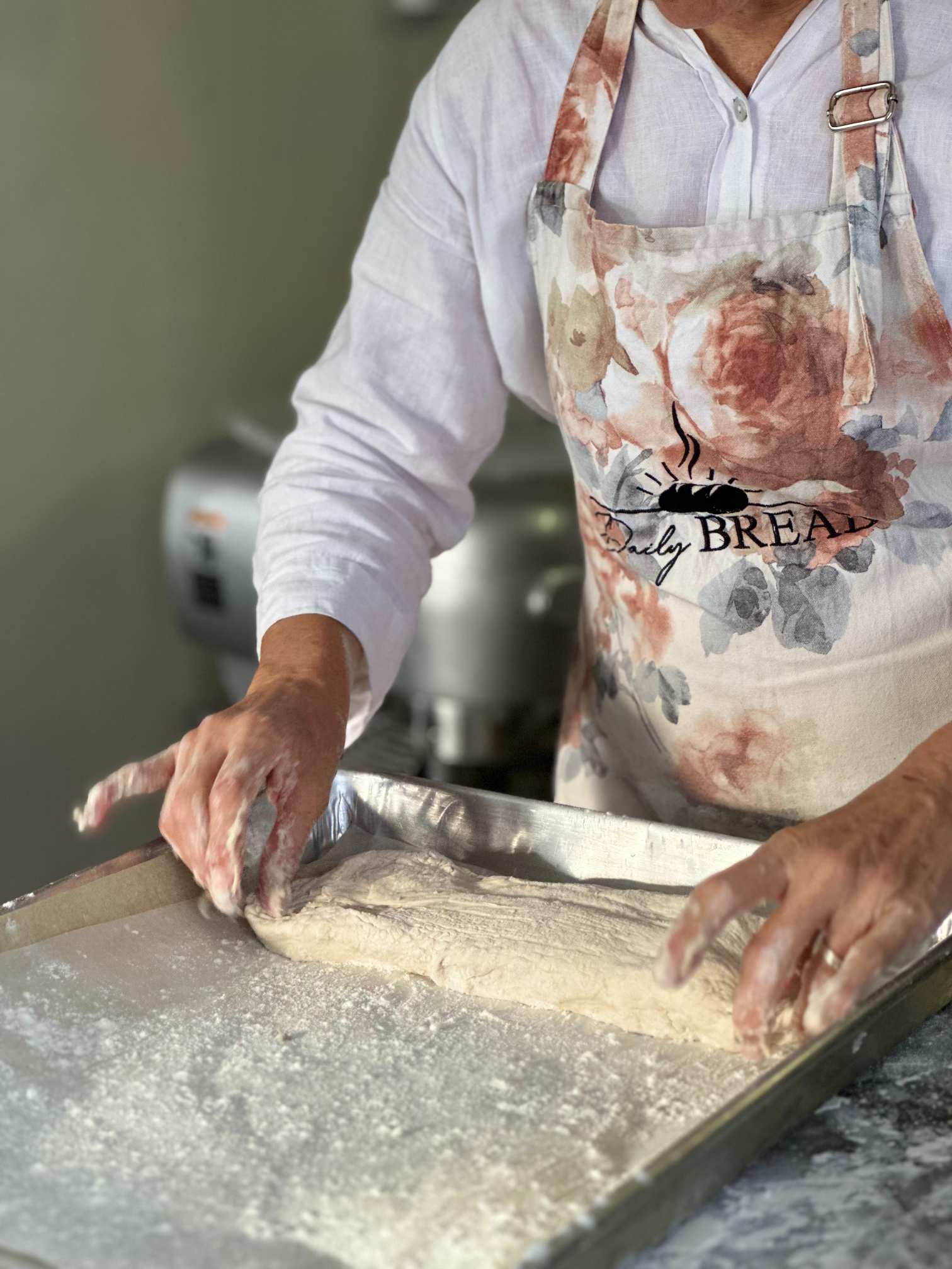 A baker rolling bread dough